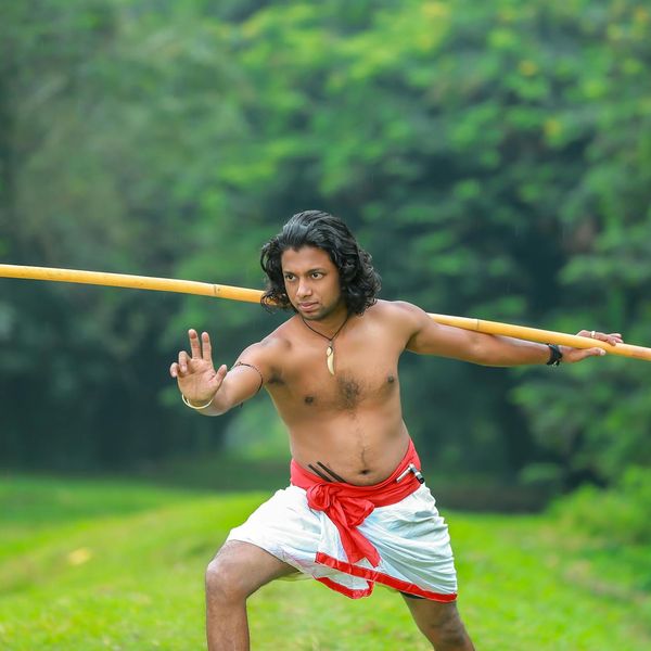 Man holding a difficult balance pose with focus and determination.